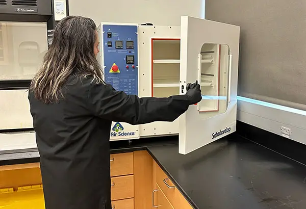 A woman opening the Safe DEVELOP™ Fingerprint Development Chamber