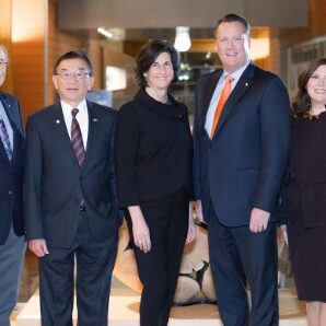 Seven people in formal attire stand in a well-lit hallway, marking a significant moment after Bellevue passes its biannual budget. Their poised stance captures a sense of accomplishment and anticipation, perhaps linked to new recruiting initiatives or upcoming foundation grants.